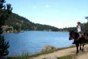 Horse riding past mountain lakes