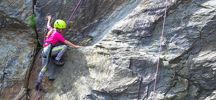 Young girl rock climbing family adventure holiday