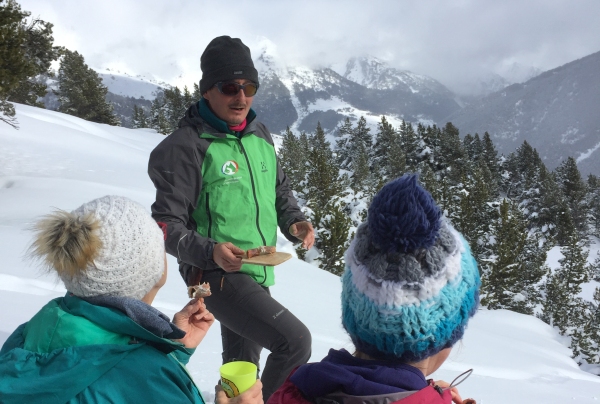 Local guide sharing local products on a snowshoeing outing